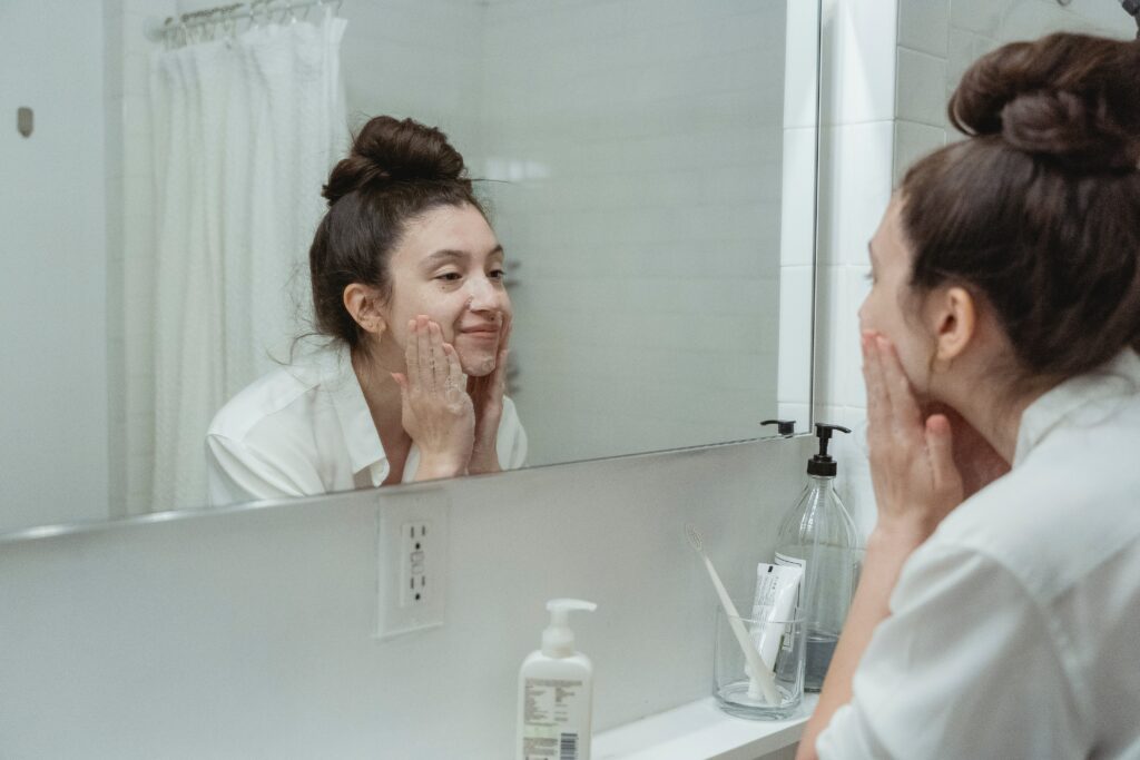 lady applying face cream in the mirror