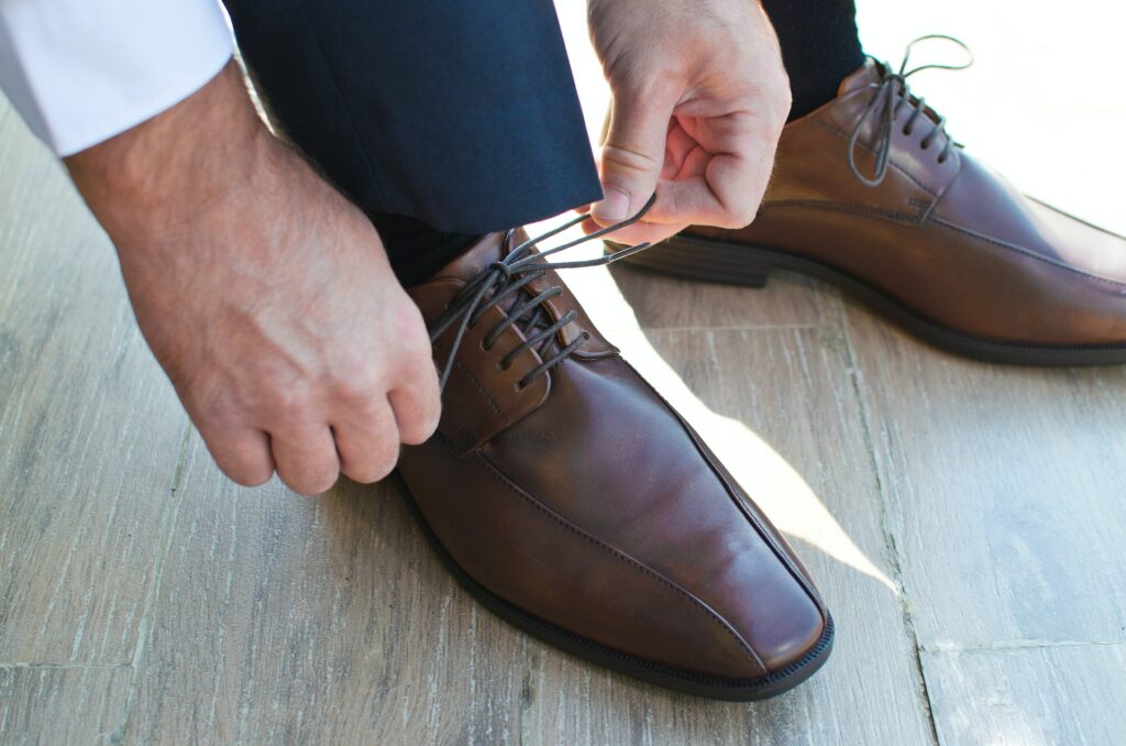 Brown shoes being tied