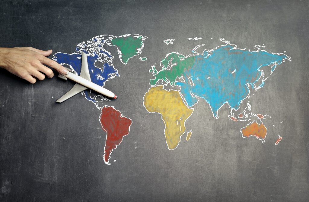 World map with a toy aeroplane for illustration