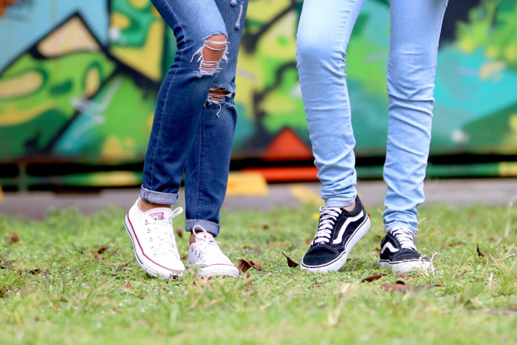 Male and female wearing jeans with Converse chucks and classic Vans sneakers