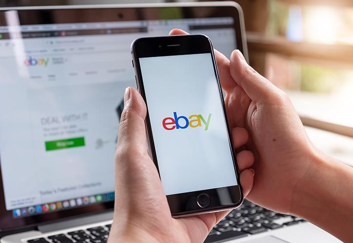 eBay app user on mobile and desktop in background