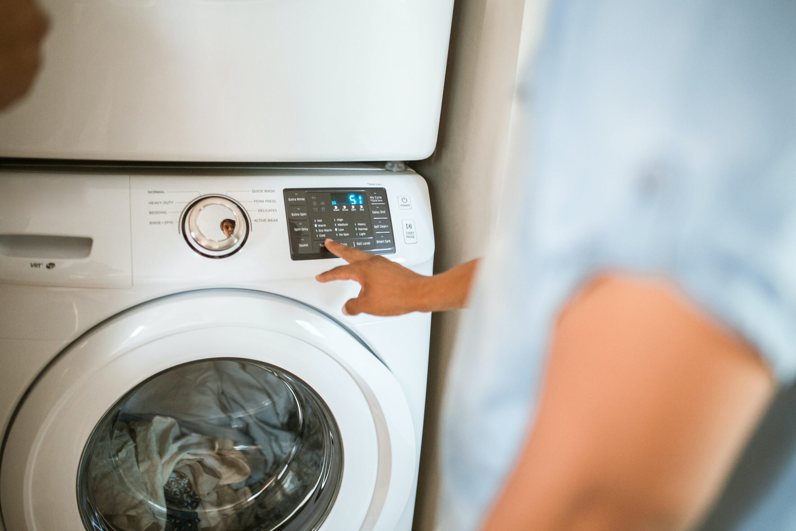 Male turning on a washing machine